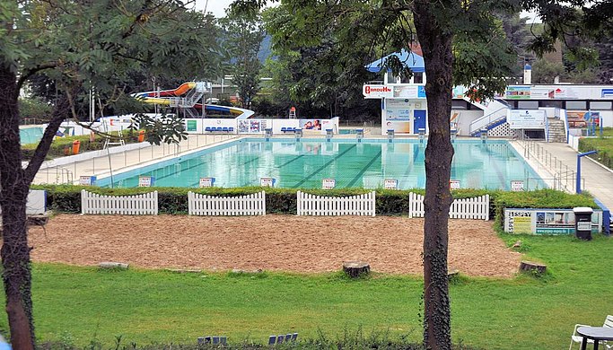 Das Bild zeigt ein Schwimmbecken in einem Freibad aus der Distanz.