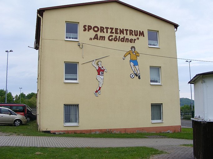 Das Bild ein Gebäude mit dem Schriftzug Sportzentrum Am Göldner und Figuren beim Fußballspielen bzw. Sperrwerfen.