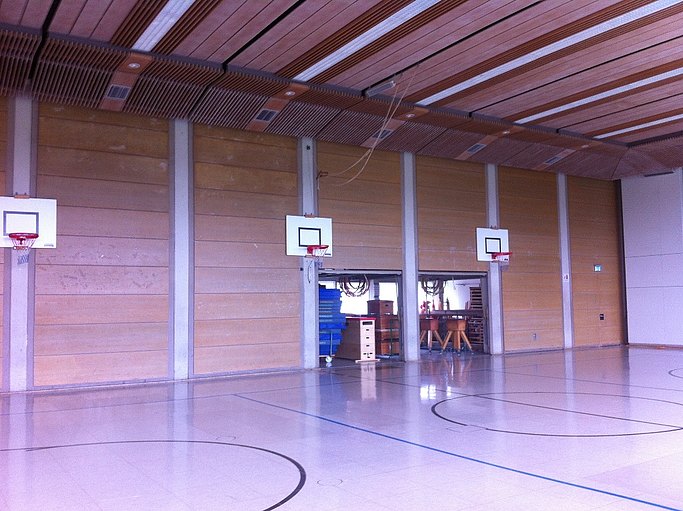 Das Bild zeigt eine Sporthalle mit Basketballkörben.