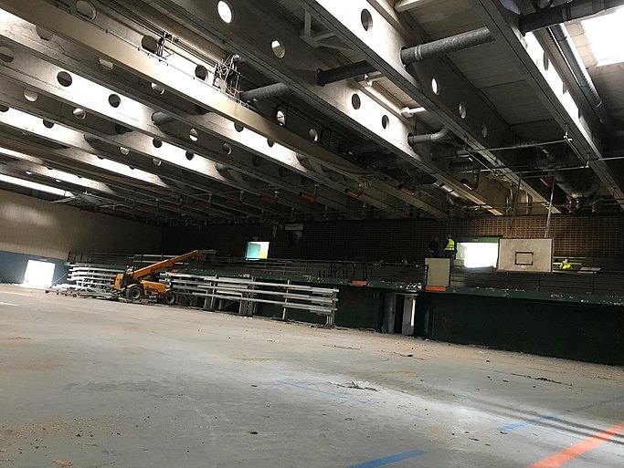 Das Bild zeigt eine Halle von innen. In der Mitte steht ein Fahrzeug.