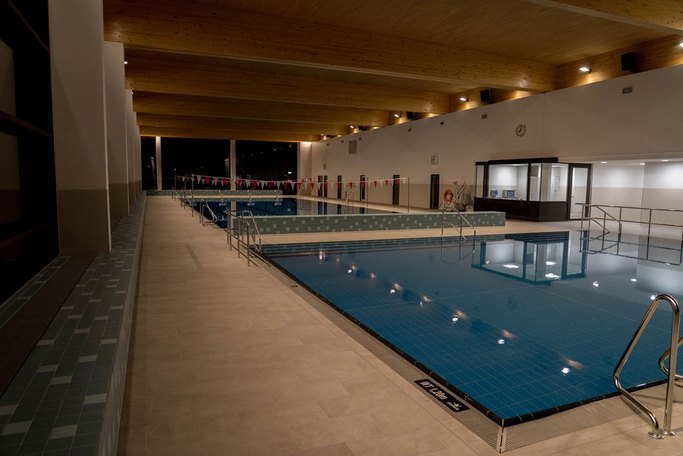Das Bild zeigt ein Schwimmbecken in einem Hallenbad.