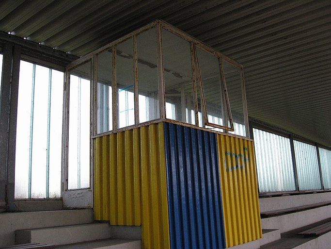 Das Bild zeigt eine baufällige Außentreppe mit gelben und blauen Geländerelementen.