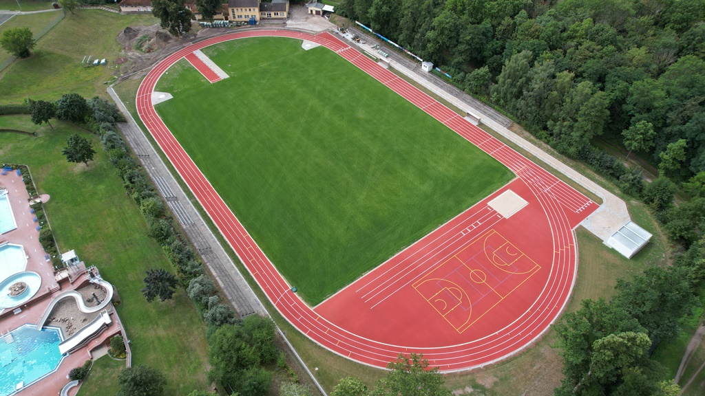 Das Bild zeigt den sanierten Fußballplatz mit Laufbahnen von oben.