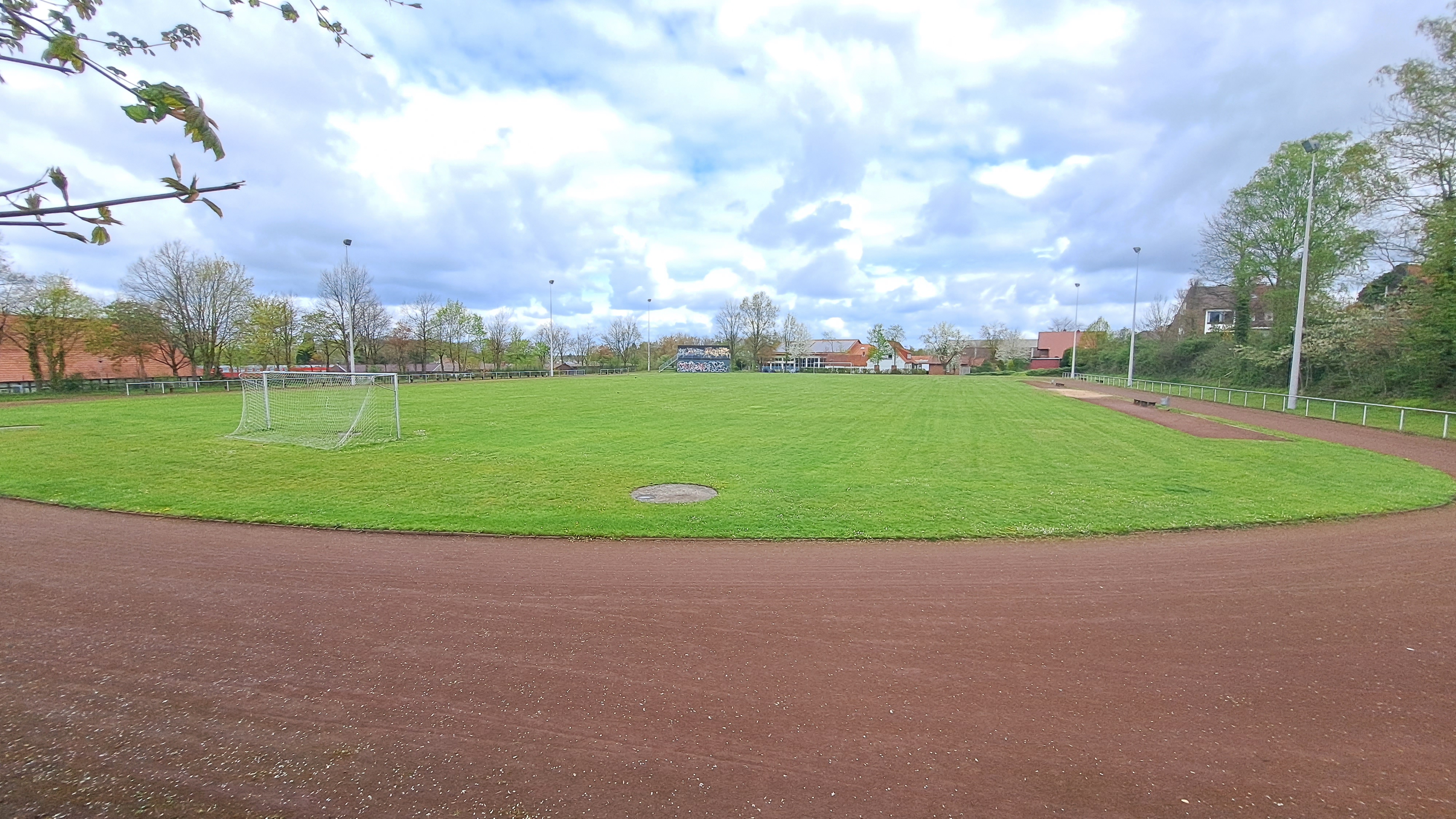 Man sieht einen Sportplatz mit einer Tartanbahn und einem Fußballfeld