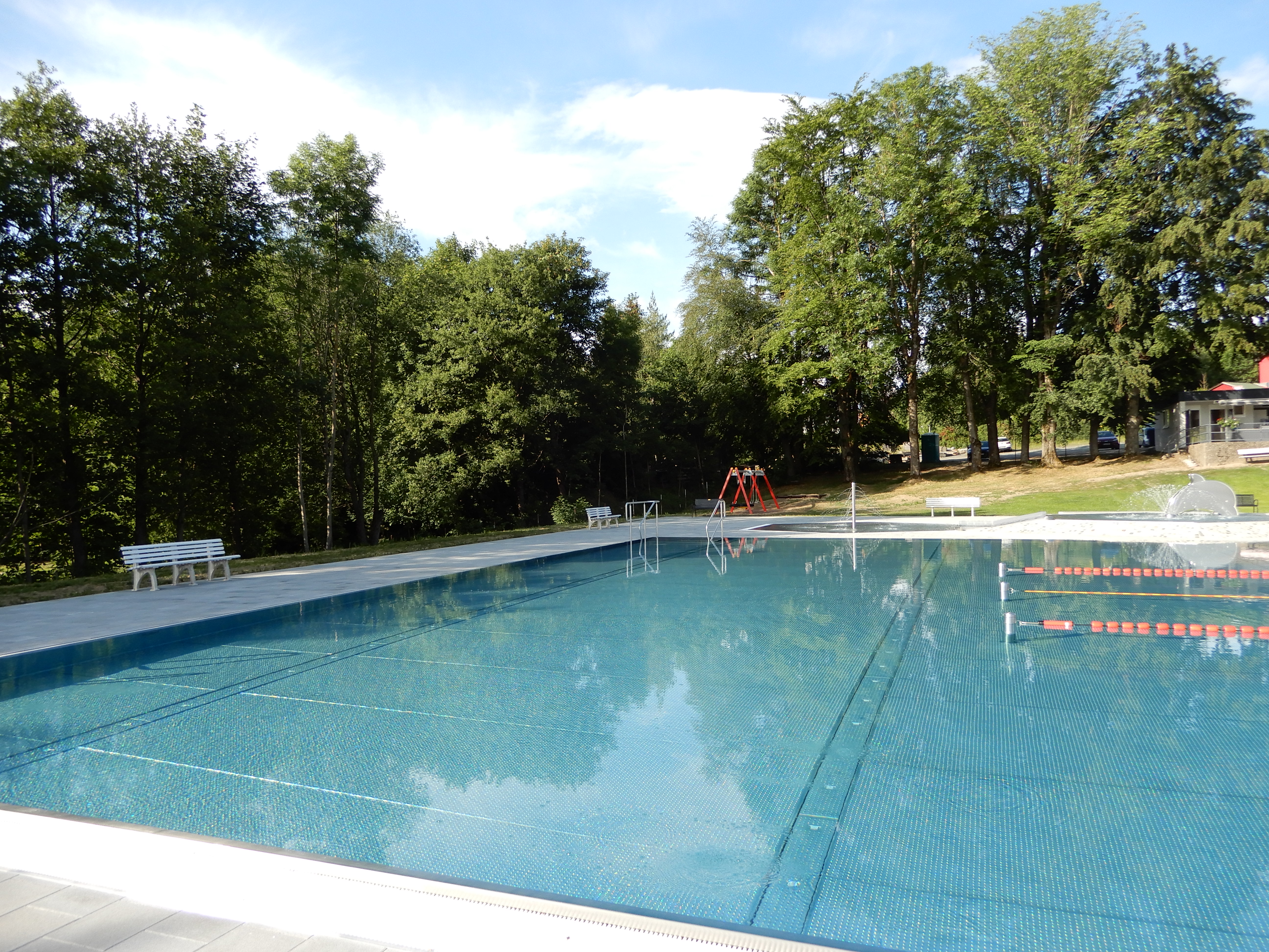 Auf dem Bild ist ein Schwimmbecken unter freiem Himmel zu sehen.