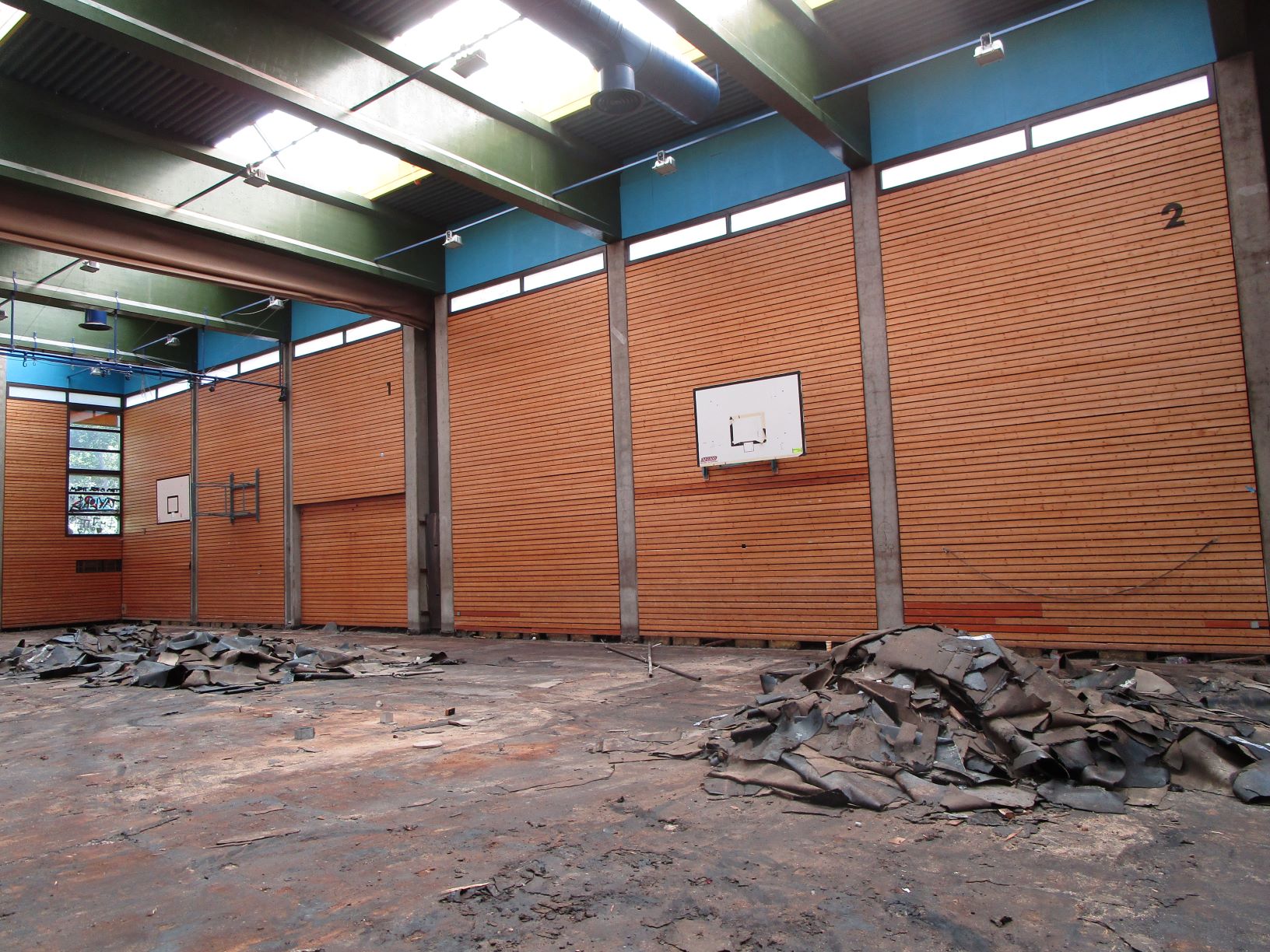 Das Bild zeigt eine Turnhalle von innen, die gerade saniert wird. Der Boden wurde abgetragen.