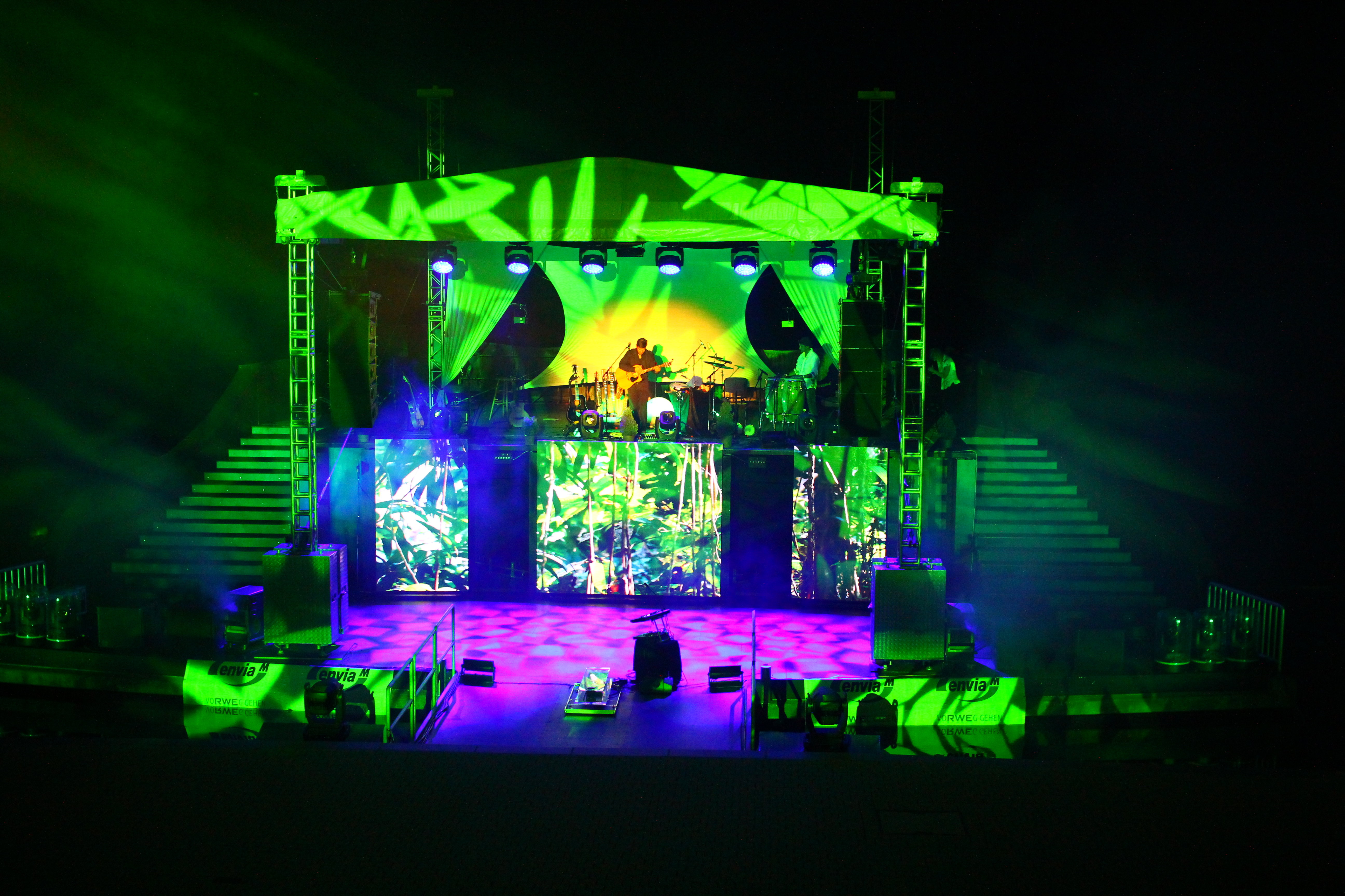 Das Bild zeigt die Seebühne in Aktion bei Nacht. Eine Bänd spielt und die Bühne ist in bunten Farben beleuchtet.
