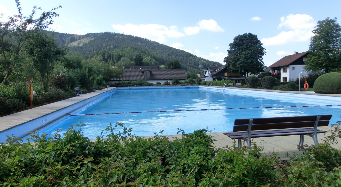 Das Bild zeigt ein volles Schwimmbecken in einem Freibad.