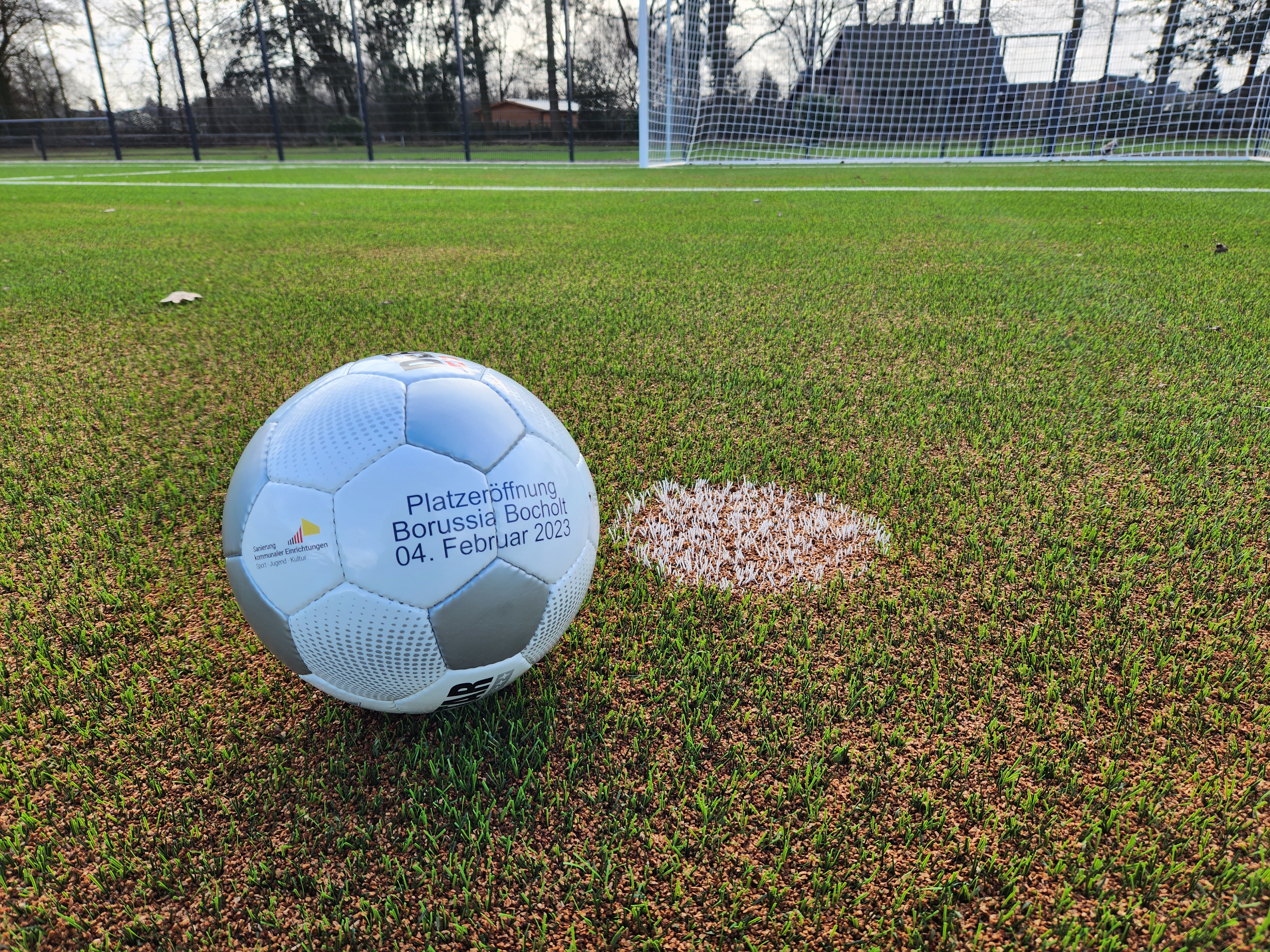 Auf dem Foto ist ein Fußball auf einem Kunstrasenplatz zu sehen.